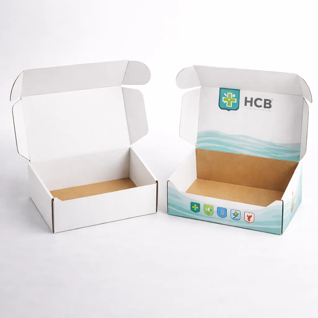 Two open corrugated cardboard mailer boxes, one blank white and one with printed pharmaceutical branding. class=